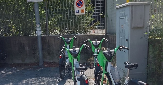Alcune biciclette del bike sharing abbandonate sopra un parcheggio per portatori di handicap