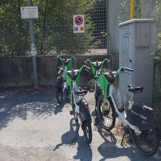 Alcune biciclette del bike sharing abbandonate sopra un parcheggio per portatori di handicap